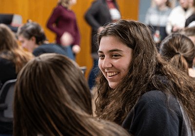 Girl smiling and talking to fellow student