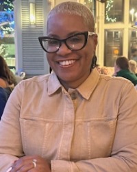 Sherita Johnson smiling at camera inside a restaurant.
