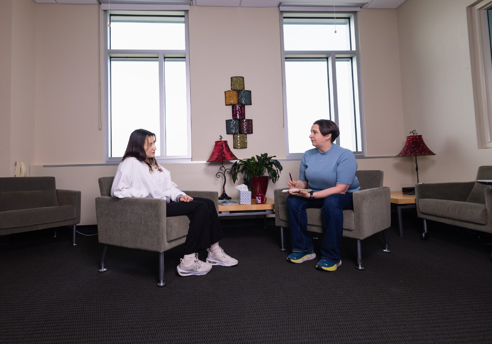 A counselor sitting in a room with a patient.
