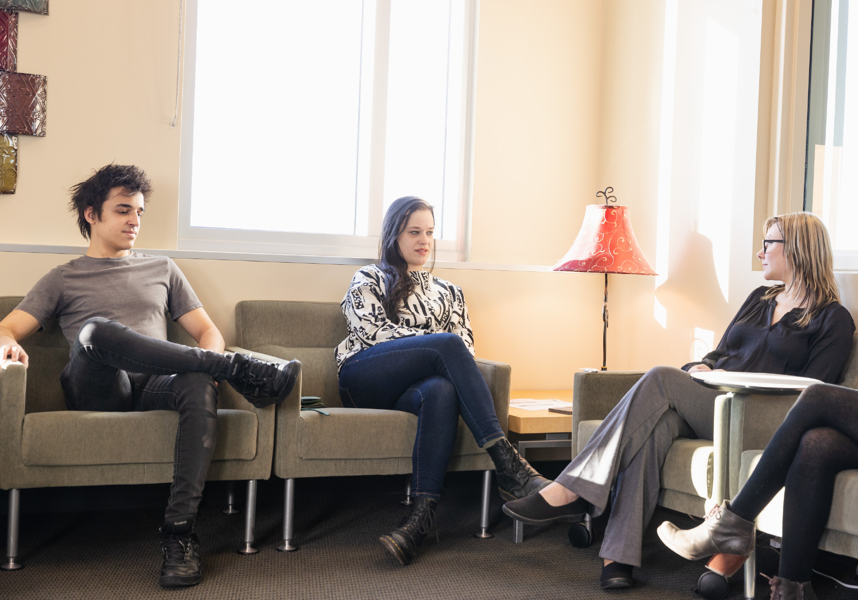 A counselor sitting in a room with two clients.
