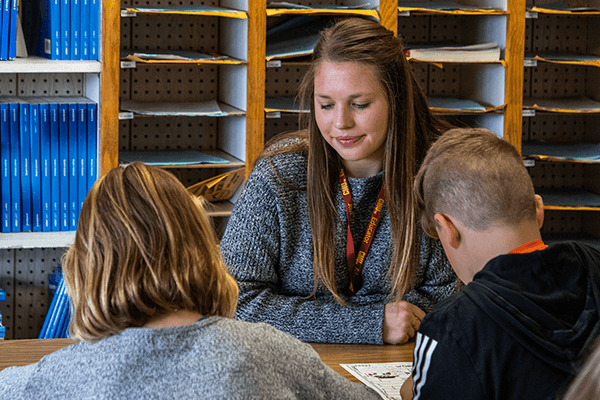 Student in a classroom working with children