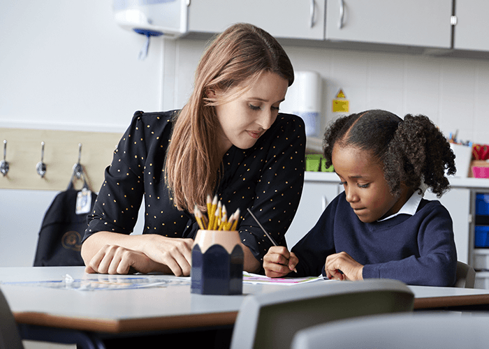 Teacher working with a young student in a classrooom