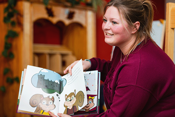 Education student reading a book to a class.