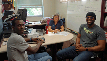 Interns Kenneth Bao (Sierra Leone) and Mori Ogundipe (Nigeria) meeting with Kim Gribben for an internship kick-off meeting.