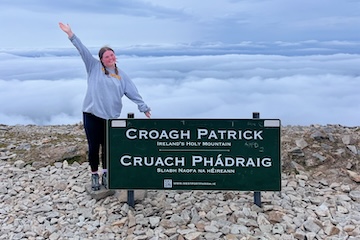 Amyah Seybert standing next to the Croagh Patrick sign in Ireland.