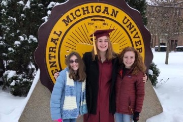 Sarah Spearing, Alexis Gostlin, and Chloe Straub posing in front of the CMU seal with snow on the ground.