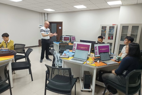 Chad Waldron instructing a group of people sitting at computers in a classroom.
