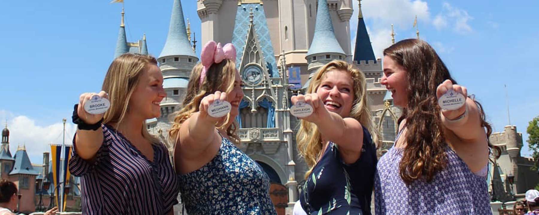 four girls holding their Disney name badges at Disney World