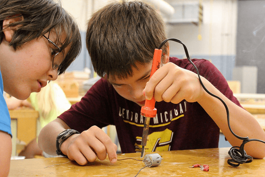 Two boys looking and working on electrical components