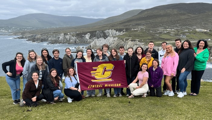 Ireland-Group-2022 Group photo of CMU students holding a CMU flag