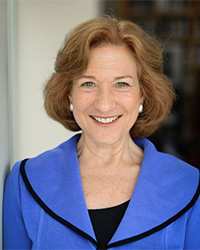 Closeup image of Debórah Dwork wearing a blue suit jacket over a black shirt