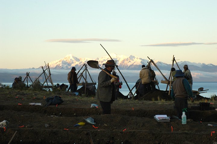 Sergio Chavez carries a shovel over his shoulder and walks through an archaeology research site in the Lake Titicaca Basin of Bolivia.