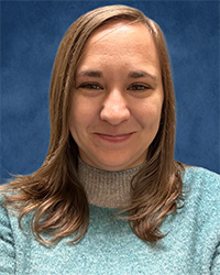 20261001_Holly_Lewis_200x250 Closeup image of Holly Lewis wearing a light blue sweater