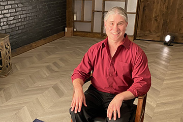English professor Jeffrey Weinstock seated in a chair for an interview.