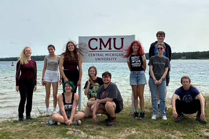 Students in Professor Robert Fanning’s English course, “Wonder and Wonder,” stand next to a Central Michigan University sign on Beaver Island.