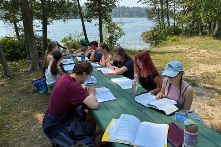 Students in Professor Robert Fanning’s English course “Wonder and Wonder” sit at tables reading on Beaver Island.