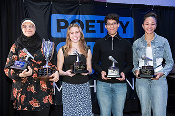 Four students stand in a line holding trophies during the 2025 Poetry Out Loud state finals