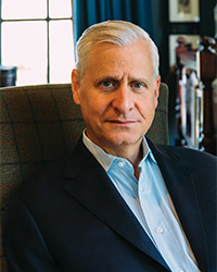Closeup image of Jon Meacham wearing a dark suit jacket and collared shirt