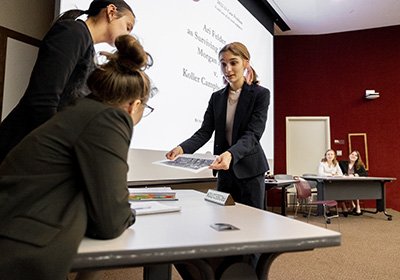 Students examine a paper while conducting a mock trial in Anspach Hall.