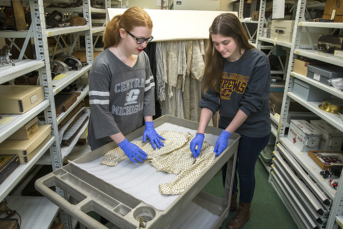 Students carefully handle clothing in the Museum collections