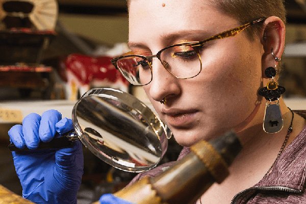 Museum Studies student examines artifact