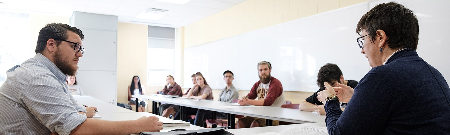 A group of students sitting at tables in a classroom