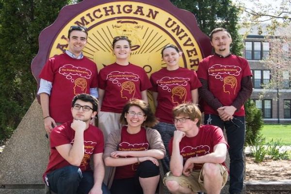 A group photo of the student philosophers group in front of the Central Michigan University seal.