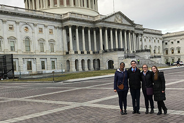 four students standing outside the Washington D.C. capitol building