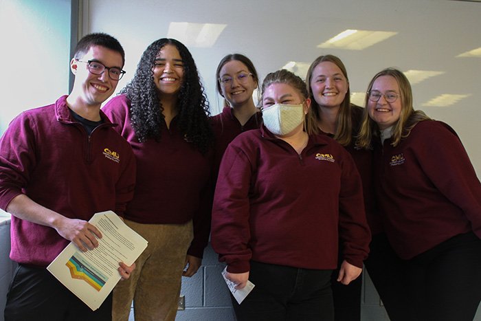 Nonprofit Leadership Student Alliance students wearing CMU shirts 700x467 Six students in the Nonprofit Leadership Student Alliance program wearing maroon shirts stand in front of a dry-erase board.