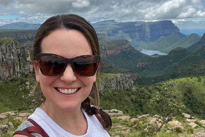 Closeup image of Andrea LaFontaine with the Blyde River Canyon in South Africa behind her.