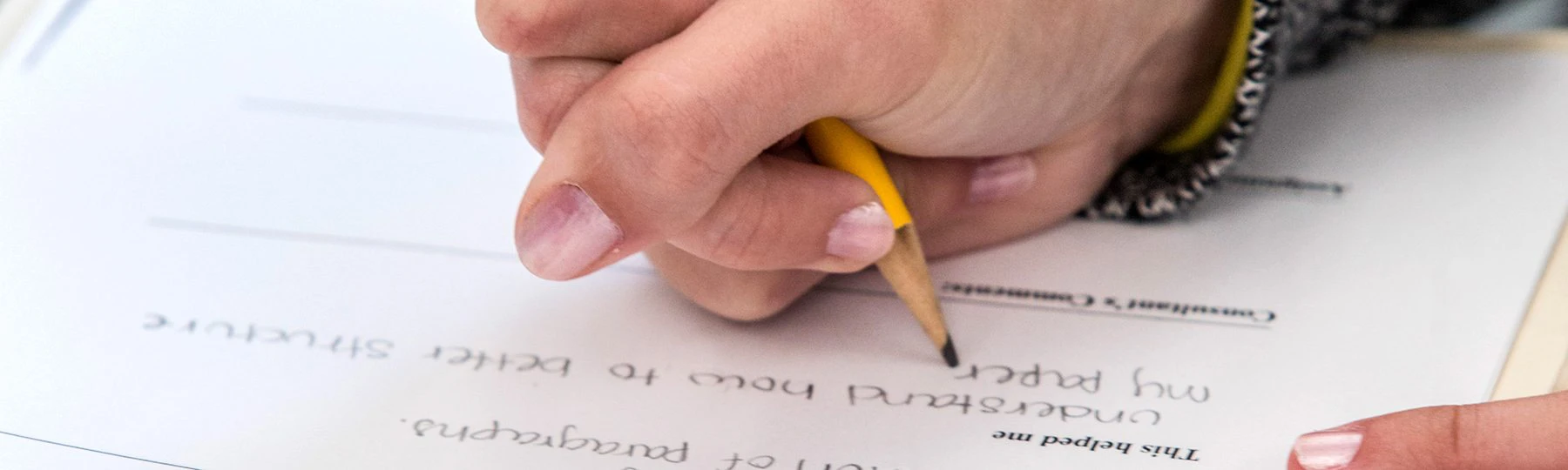 Close-up of hand writing with a pencil