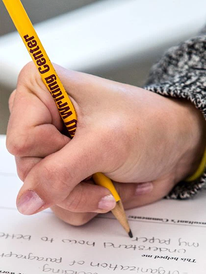 Close-up of hand writing with a pencil