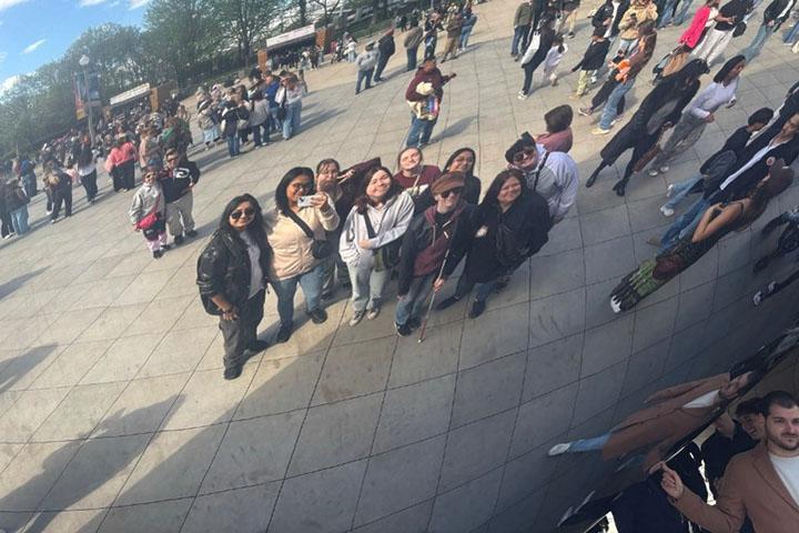 Image of a reflection of a group of individuals standing next to The Bean in Chicago.