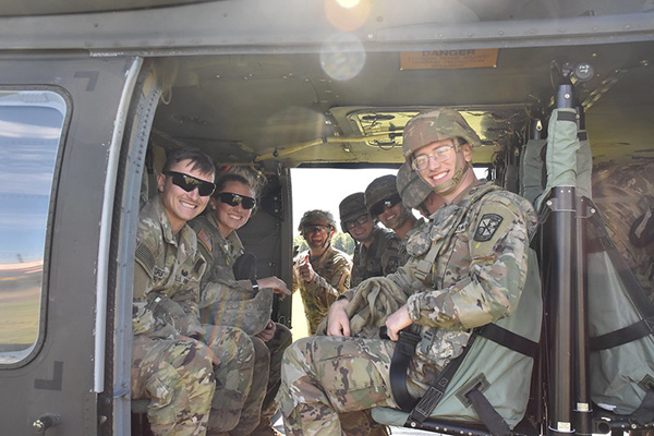 ROTC cadets look out from inside a helicopter during training in Fall 2022