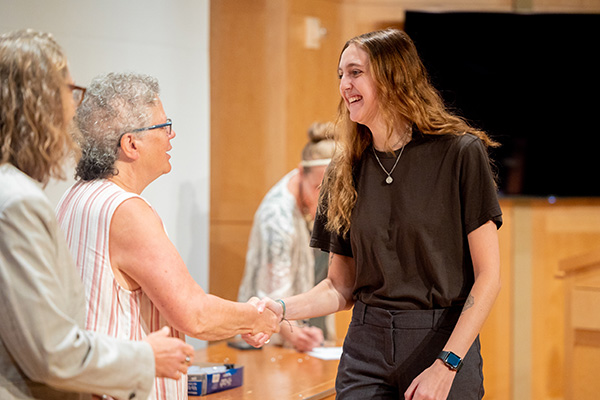 Student shakes hands with faculty during the annual Central Michigan University Social Work Convocation Ceremony.