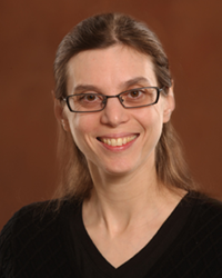 Xantha Karp wears a black blouse while posing for a headshot.