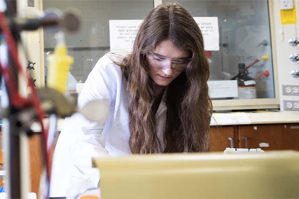 Student examining biological samples in a lab setting.