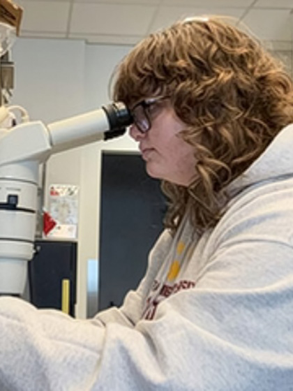 a woman looking through a microscope