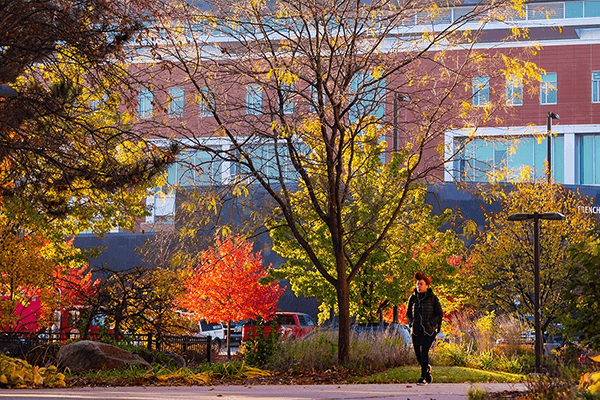 A student walking Outside of Pearce Hall in the Fall.