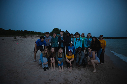 A group of students gathered on the beach at the CMU Biological Station on Beaver Island.