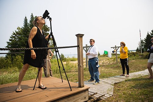 Adult student in a black dress observing anomalies in the sky while taking a CMU Astronomy class at the CMU Biological Station.