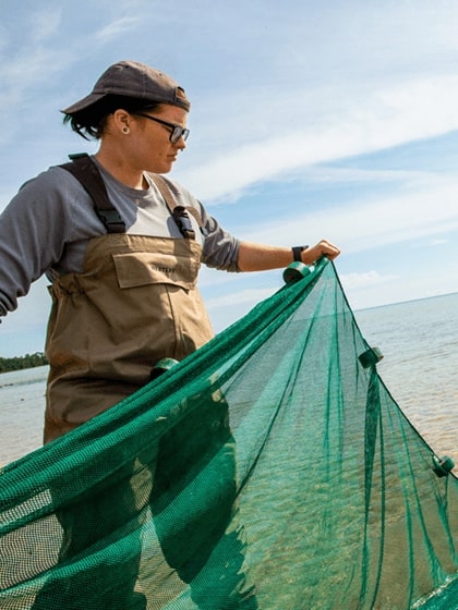 Student researcher with a net gathering samples in the a Great Lakes Coastal Wetland