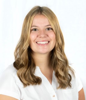Meghan VanDamme in a white shirt in front of a light colored wall