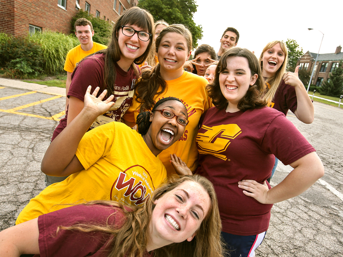 Central Michigan University students pose for a photo outside a residence hall.
