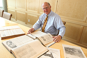 a man sitting at a table with open books