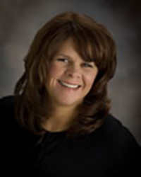 Kelly Wehner wears a black blouse and smiles at the camera.