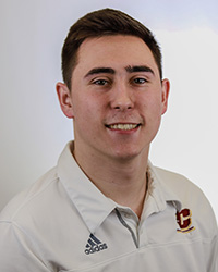 a man with short dark hair in a white CMU shirt smiling for a photo