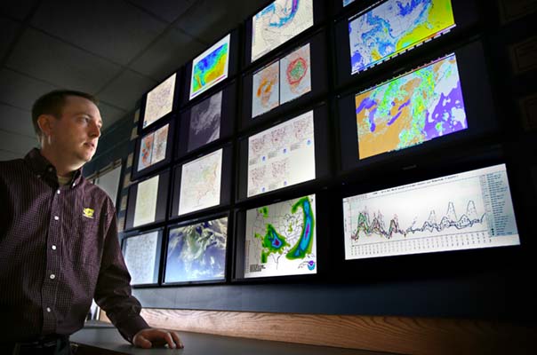 Professor Marty Baxter in front of the CMU Weather Wall.