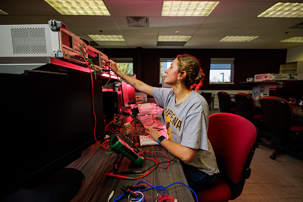 a person adjusting the knobs on a piece of electrical equipment