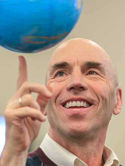 Geography faculty member, Mark Francek, spinning a globe on his finger